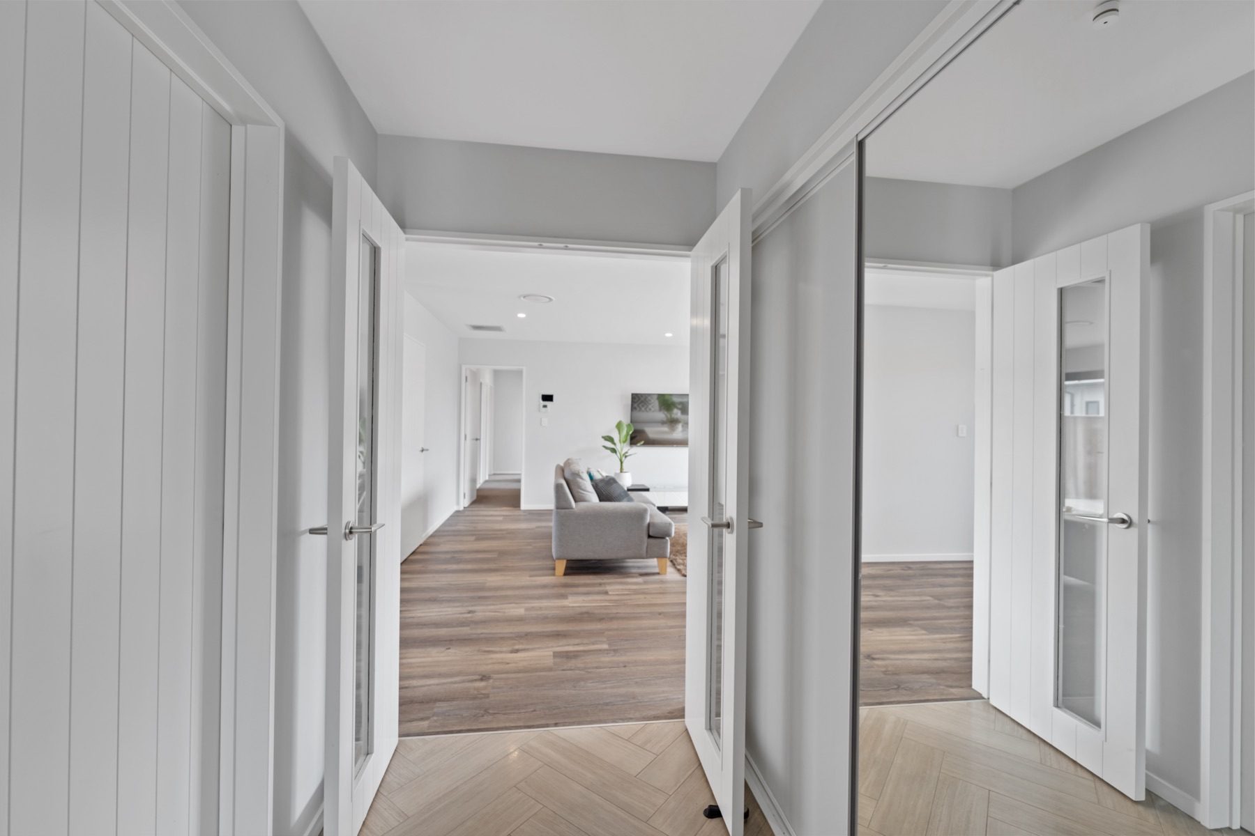The entry at Milns Park, laid in herringbone tile, with glazed double doors opening into the hall.