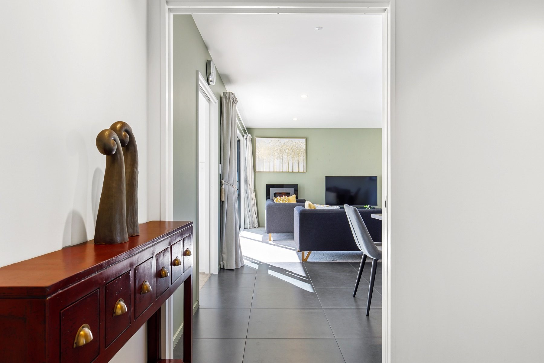 The hallway at Old Stone Lane, opening through a wide return into the living room and its gas fire.