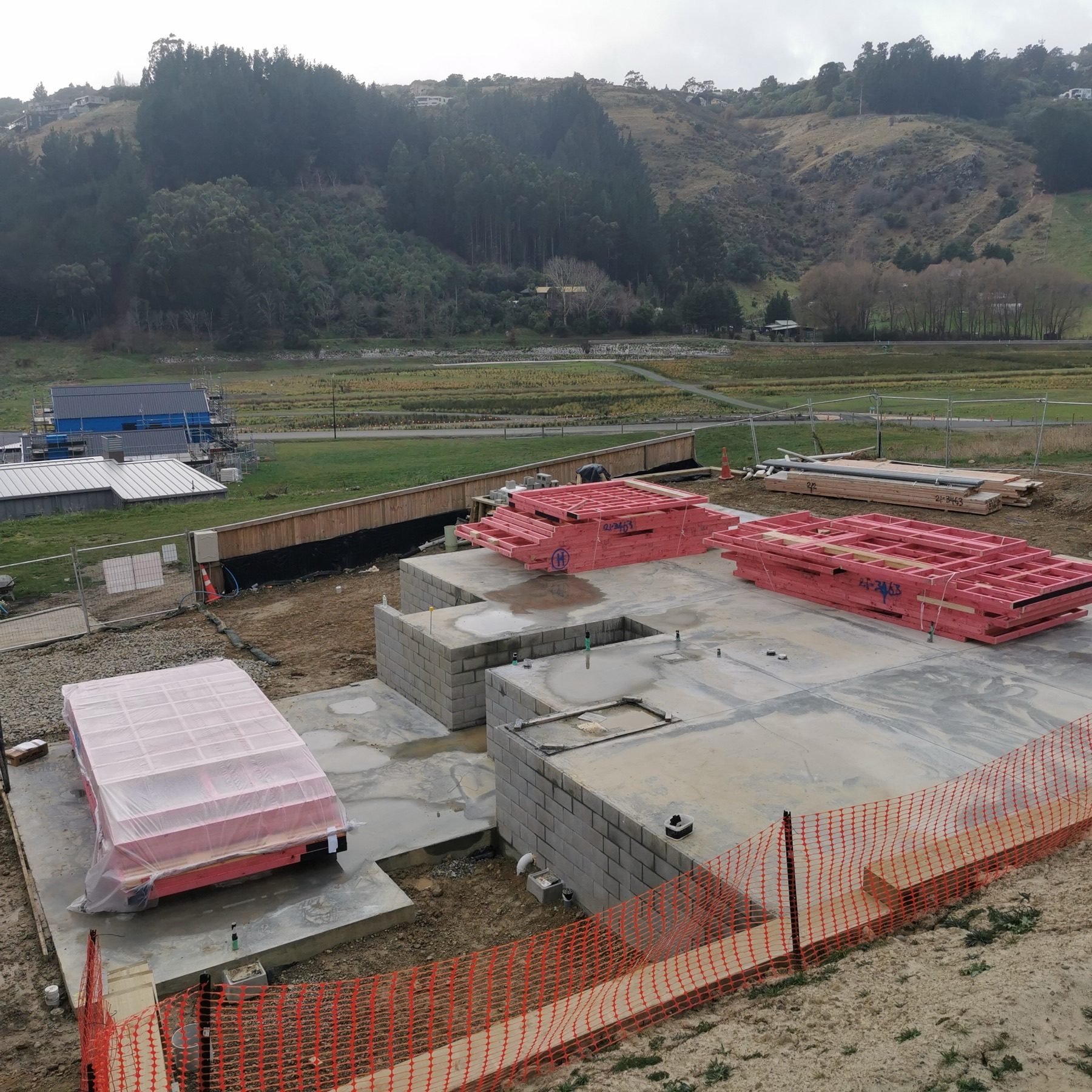The completed slab and block walls with pre-nailed wall frames delivered and stacked ready to stand, June 2022.