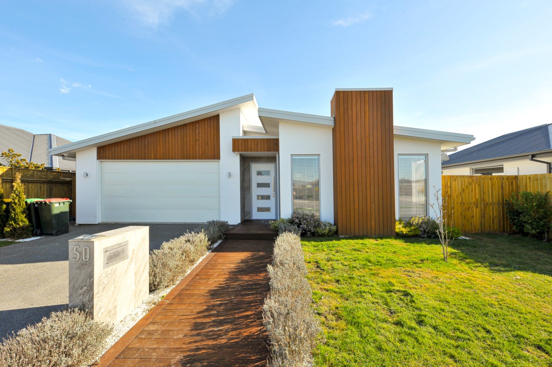 The Vernon Drive street elevation with its cedar entry tower and the timber path to the front door.